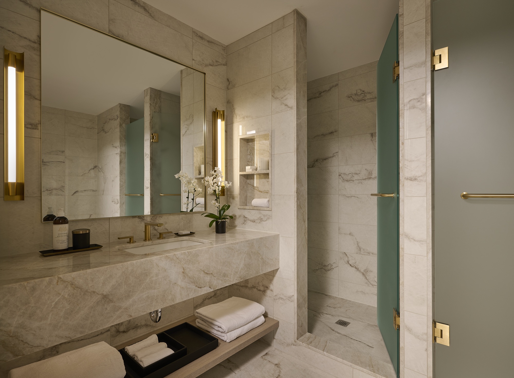 A marble bathroom with walk-in shower in a Glenhill Hotel suite